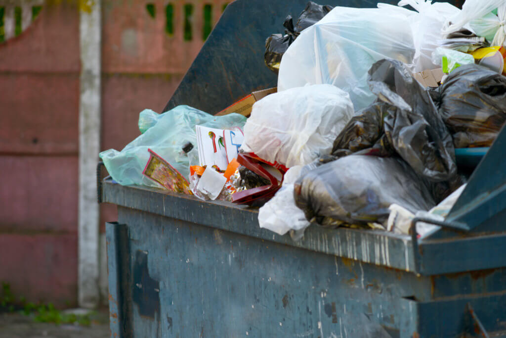 overflowing dumpster creating foul smells in your business