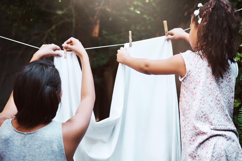 mother and daughter hanging laundry to save on energy